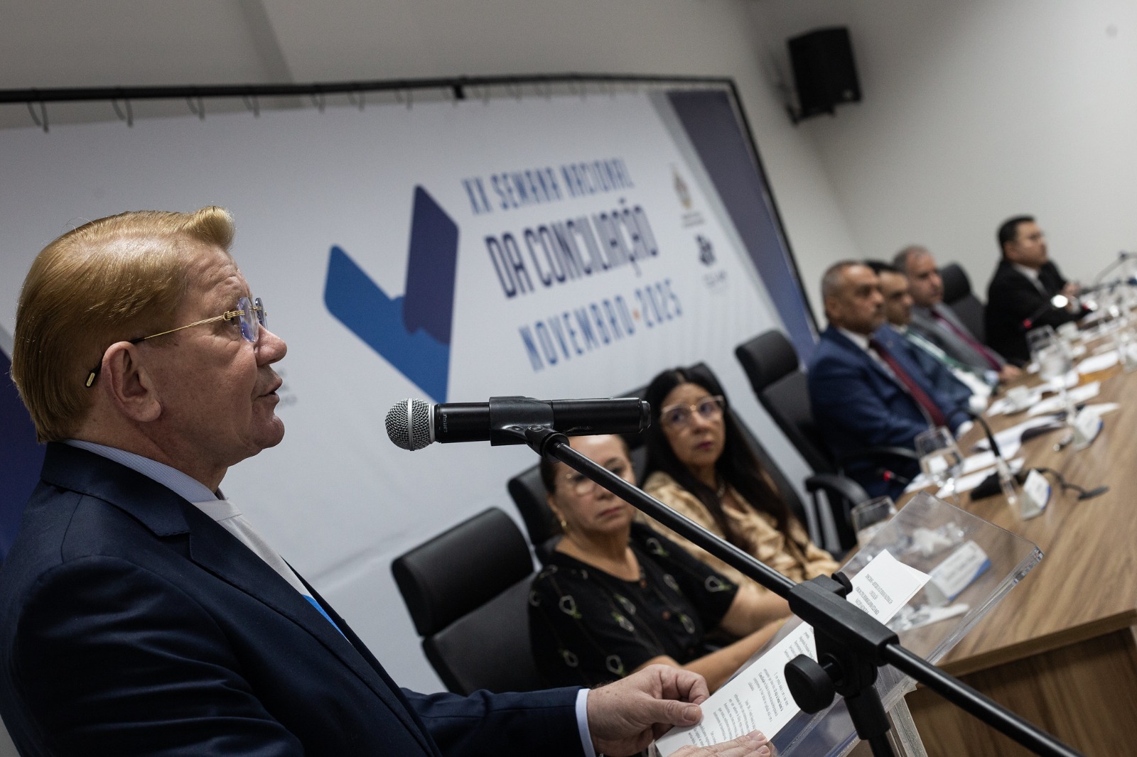 Foto mostra à direita o corregedor-geral do TJAM, desembargador José Hamilton, tendo ao lado a mesa de autoridades da abertura da Semana Nacional de Conciliação