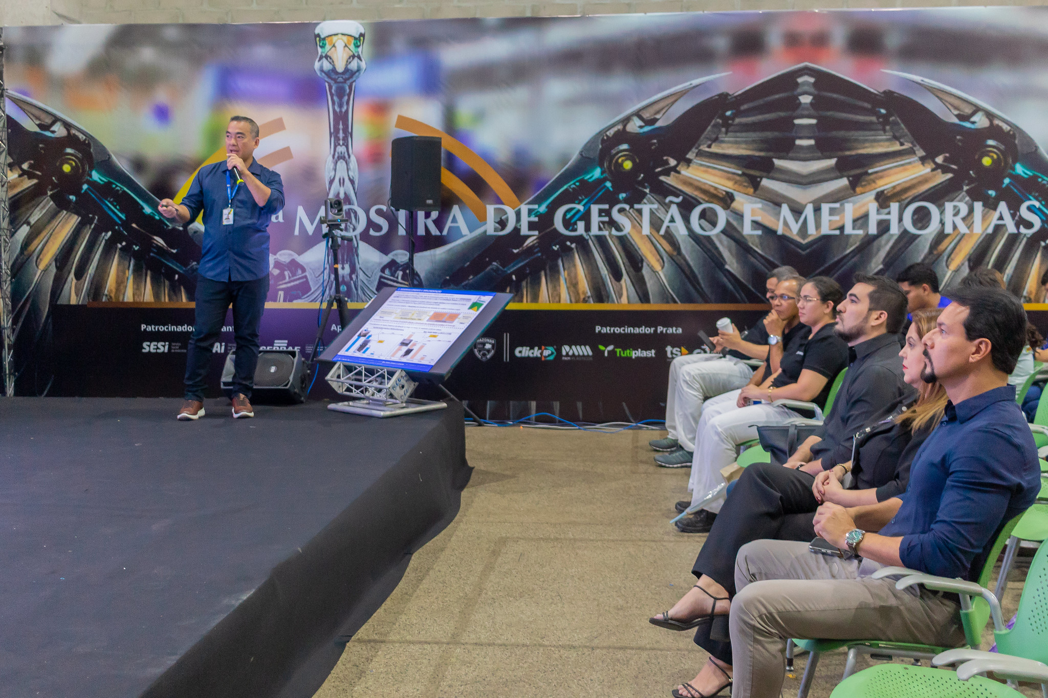 Foto mostra o servidor Djalma Takeshi Ishizawa explanando durante o Prêmio Qualidade Amazonas e sendo observado pela plateia