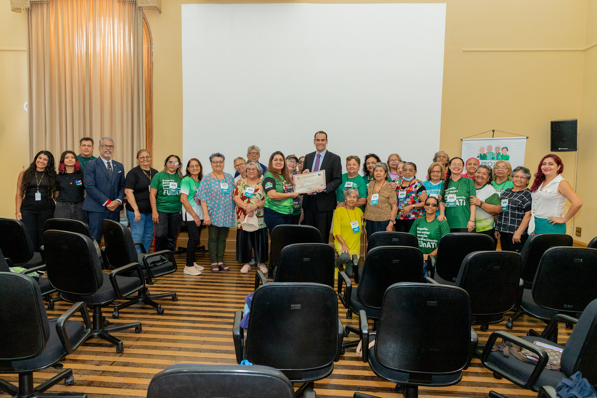 Foto mostra, ao centro, o juiz Rosberg Crozara exibindo certificado de participação no Projeto Gerações e ladeado por participantes da iniciativa