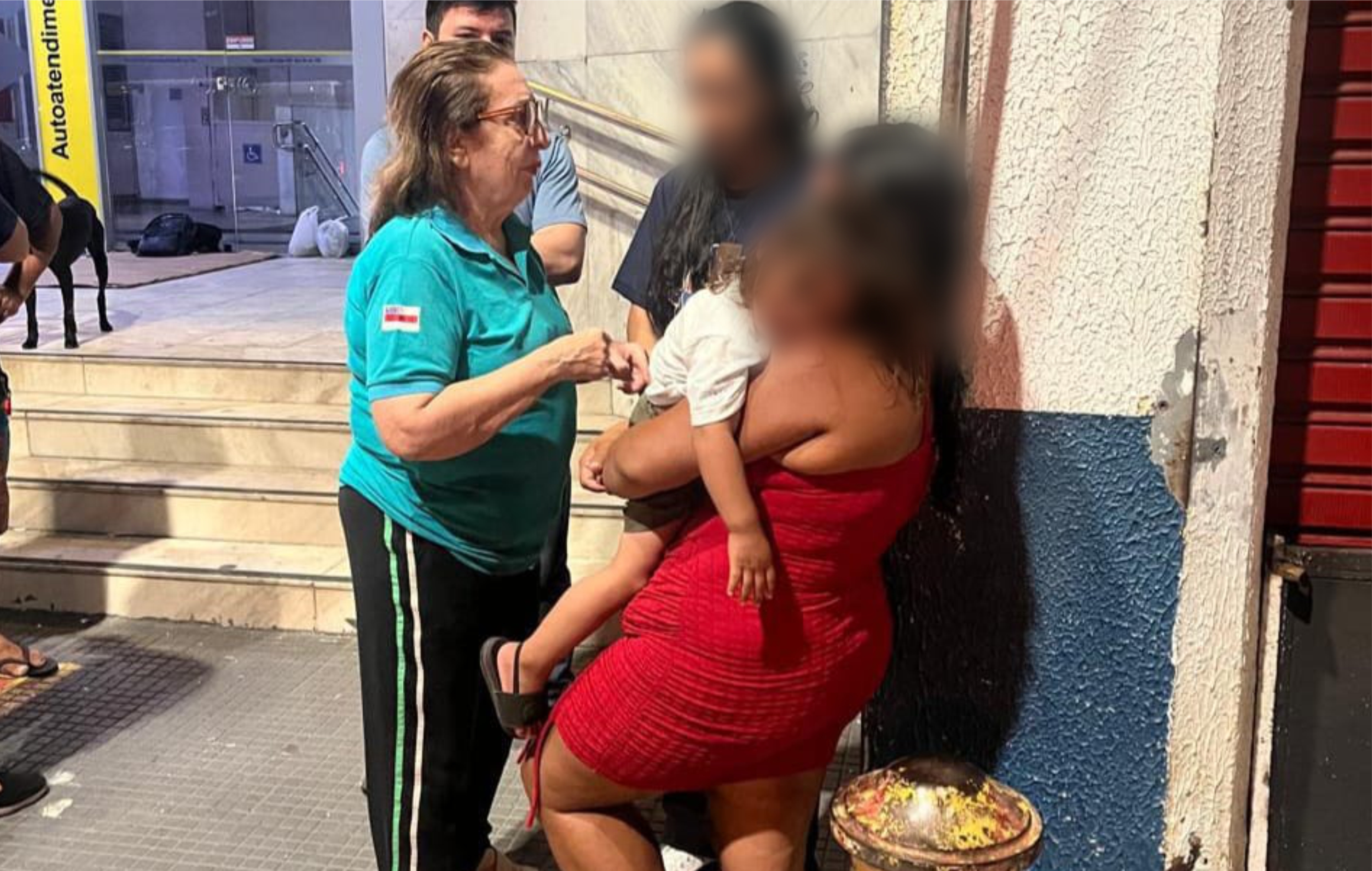 Foto traz a desembargadora Joana Meirelles abordando pessoas em situação de rua  