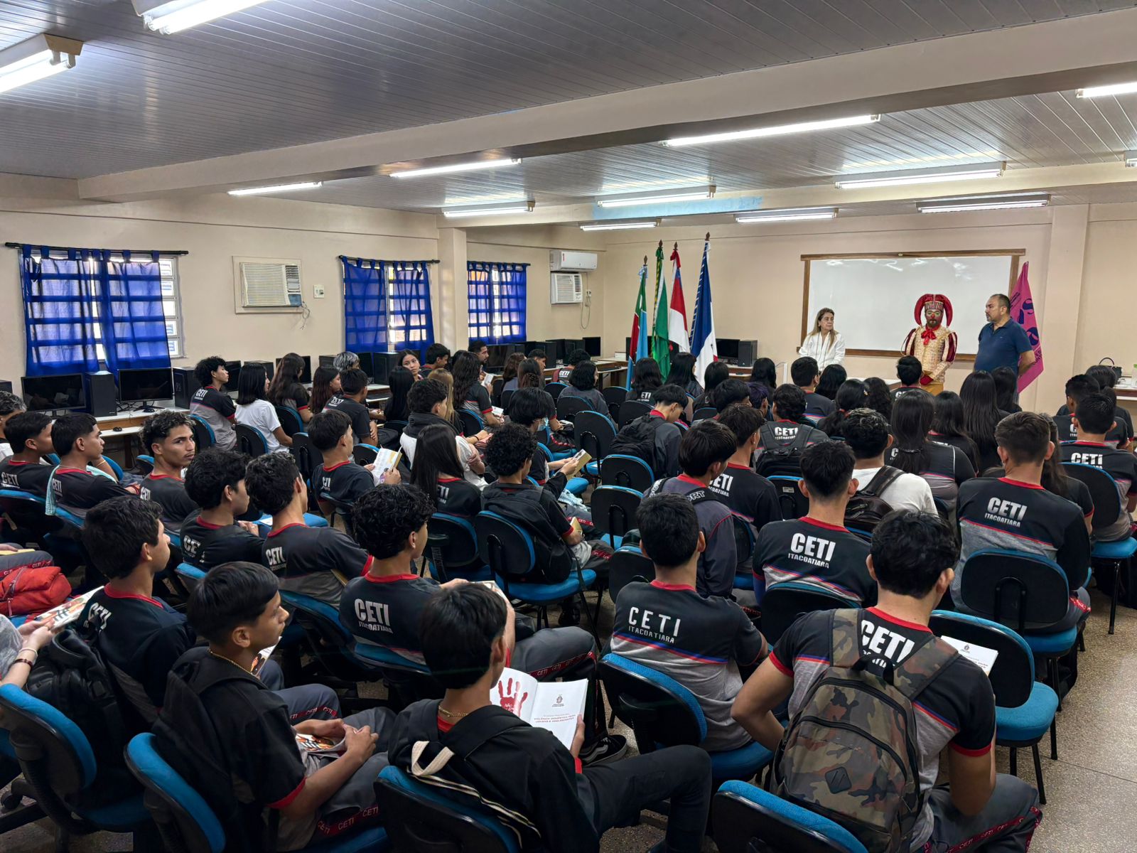 Foto mostra a desembargadora Graça Figueiredo palestrando para alunos em Itacoatiara