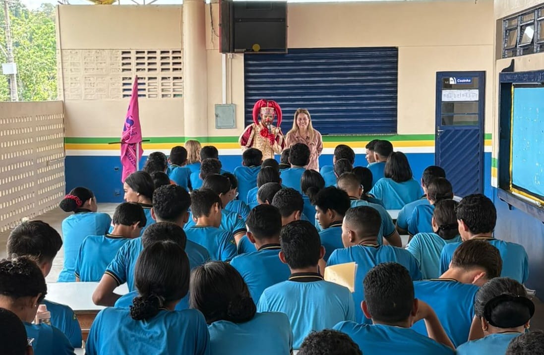 Foto mostra a desembargadora Graça Figueiredo palestrando para alunos em Rio Preto da Eva