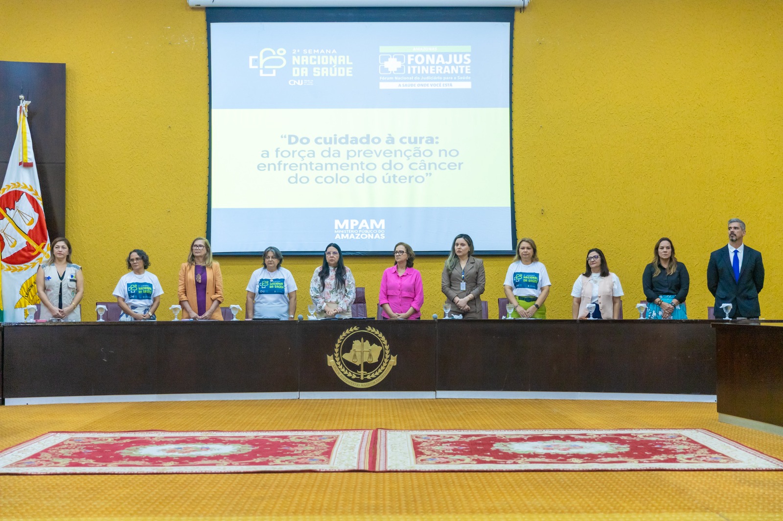 Foto mostra autoridades em pé durante evento da Semana Nacional da Saúde 2026